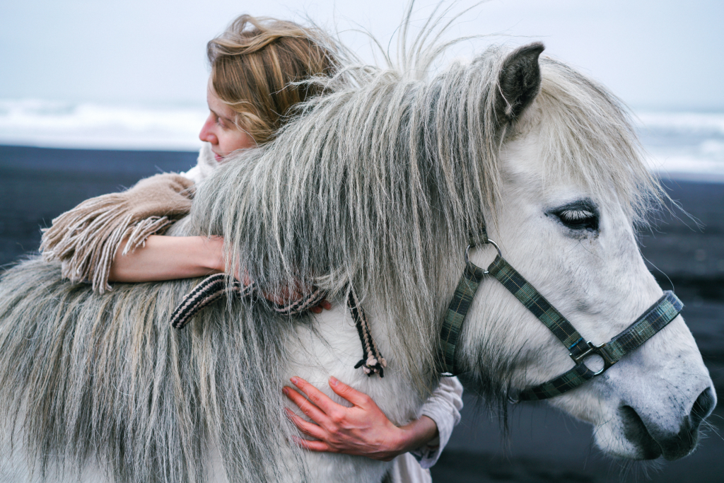 Pet Therapy: approcci e benefici degli amici a 4 zampe; Donna che abbraccia il suo cavallo bianco appoggiandone parte del volto 