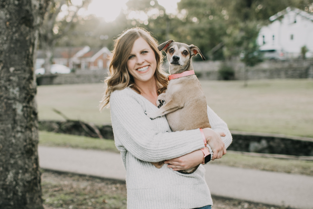 Pet Therapy: approcci e benefici degli amici a 4 zampe;  Donna sorridente che tiene in braccio il suo cagnolino.